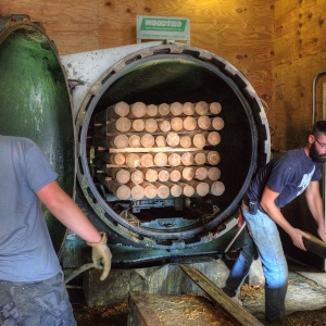 Bundles of posts being loaded into the pressure cooker